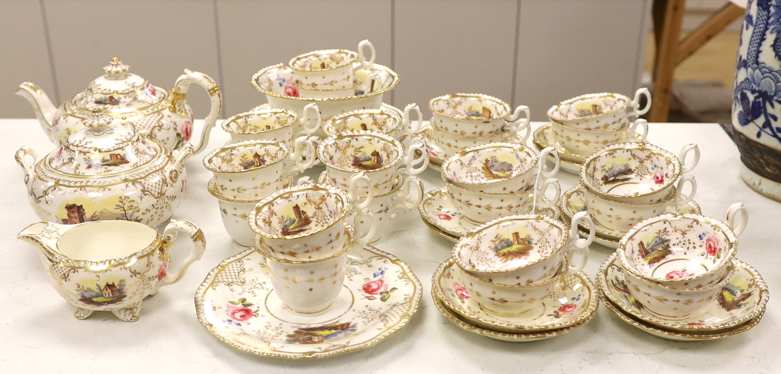An early 19th century H & R Daniel landscape painted tea and coffee set, including twelve tea cups and saucers, twelve coffee cups, a teapot, a jug and a covered serving bowl, teapot 15cm high